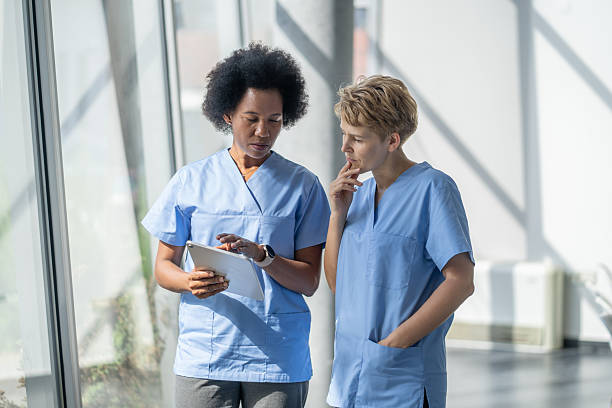 istock Two nurses consulting a digital tablet in hospital corridor 2248127647