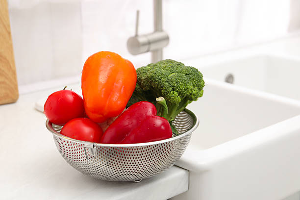 istock Fresh clean vegetables in colander on countertop near sink. Space for text 2248131858
