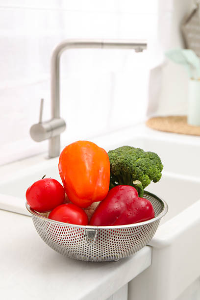 istock Fresh clean vegetables in colander on countertop near sink 2248131901