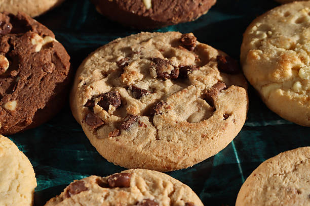istock Full frame image of rounds of chocolate chip shortbread biscuits, rows of triple chocolate chip, milk chocolate chip and white chocolate chip cookies, mottled green background, elevated view, home baking concept 2248132895