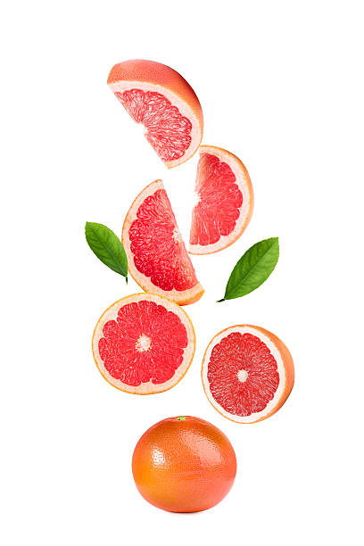 istock Fresh ripe grapefruits and green leaves falling on white background 2248136599