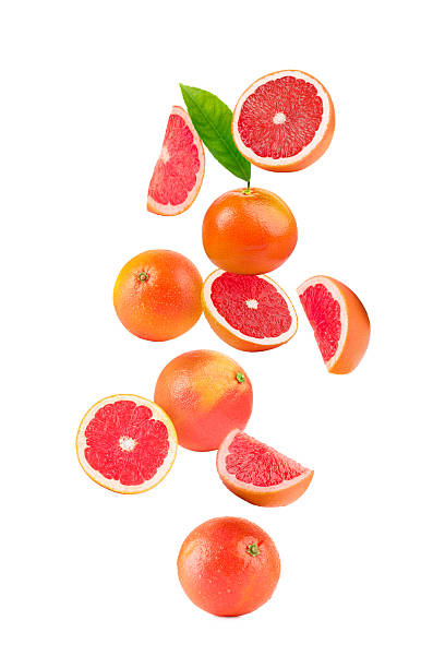 istock Fresh ripe grapefruits and green leaf falling on white background 2248136659