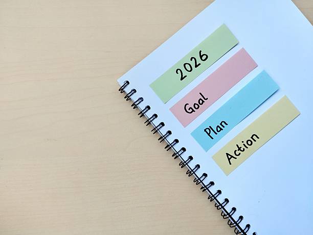 istock New year 2026 resolution concept. Goal, plan and action written on a notebook with wooden table background 2248138274