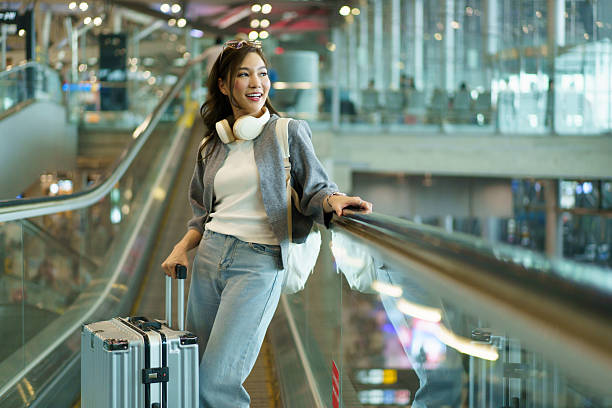 istock Asian woman pulling her suitcase while traveling through an airport. 2248139441