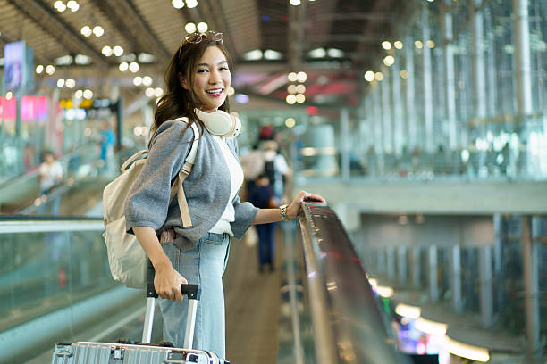 istock Asian woman pulling her suitcase while traveling through an airport. 2248139446