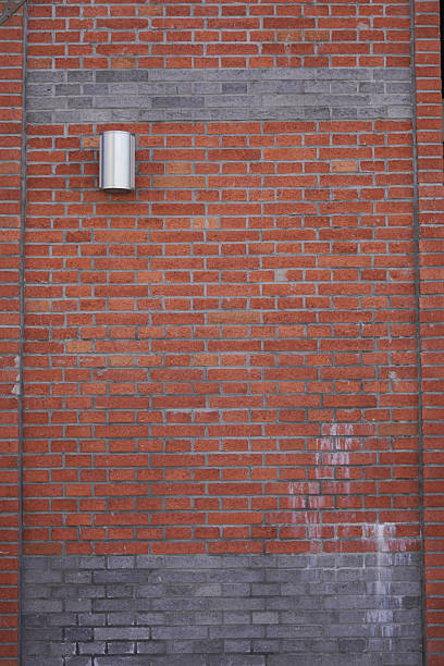 istock Close-up view of a red brick wall with a light fixture 2248140143