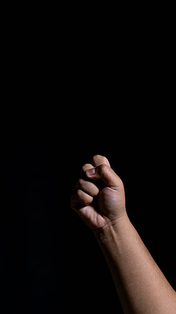 istock A tightly clenched fist illuminated by strong side lighting in a dark studio, symbolizing strength, determination, resistance, or resolve with a bold, dramatic atmosphere. 2248146823