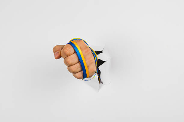 Fist breaking through white wall showing determination and strength