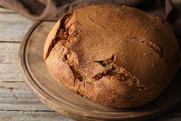 istock Freshly baked sourdough bread on wooden table, closeup 2248150074