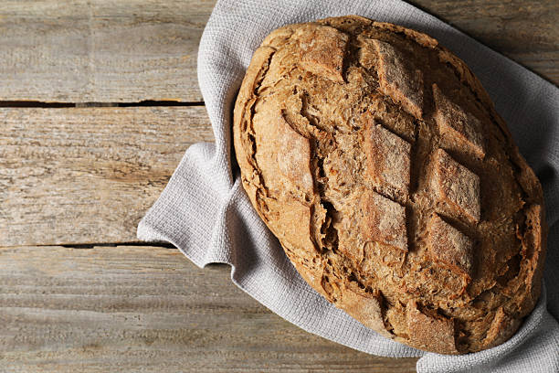 istock Freshly baked sourdough bread on wooden table, top view. Space for text 2248150140