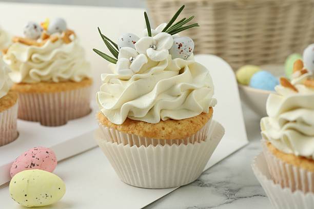 istock Tasty Easter cupcakes with vanilla cream on white marble table 2248152542