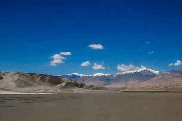 istock Vast desert landscape with snow-capped mountains under clear blue sky 2248153736