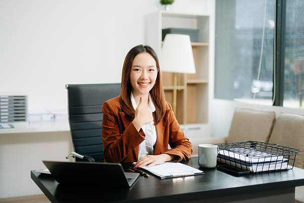 istock Young beautiful woman typing on tablet and laptop while sitting at the working white table 2248153779