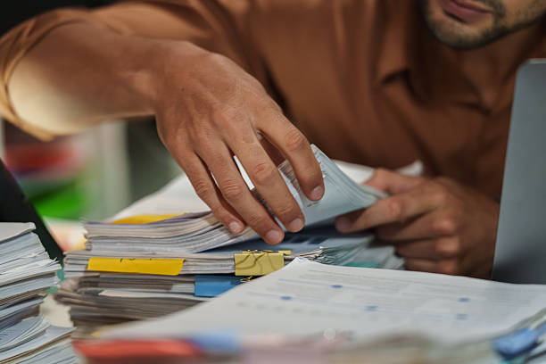 close up office employee searching and arranging documents with files and paperwork on  Desk
