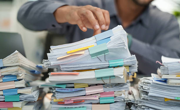 close up office employee searching and arranging documents with files and paperwork on  Desk