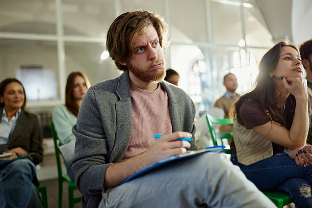 istock Worried creative man attending a seminar with his colleagues in the office. 2248155539