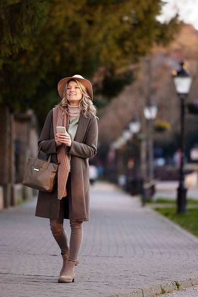 istock Happy woman using mobile phone at the street. 2248156155