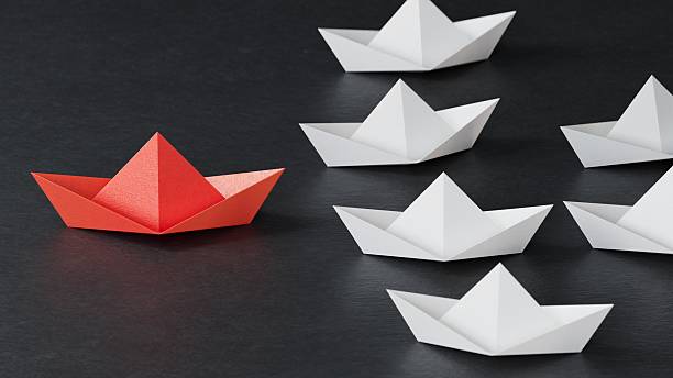 istock Different business concept.new ideas. paper art style. creative idea.Leadership concept using red paper ship among white boats.3D rendering on black background. 2248156241