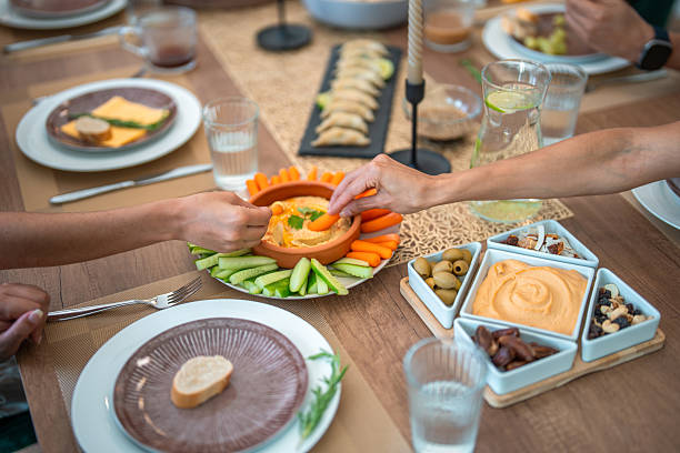 istock Hands Reaching for Hummus at a Cozy Dinner Party with Vegetables and Snacks 2248162287