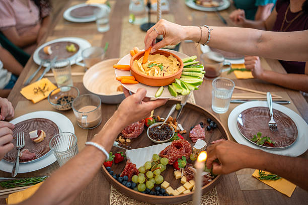 istock Diverse Friends Sharing a Feast with Gourmet Platters and Fresh Vegetables 2248162297