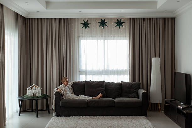 istock Boy Relaxing On Sofa In Minimal Christmas Living Room 2248162579