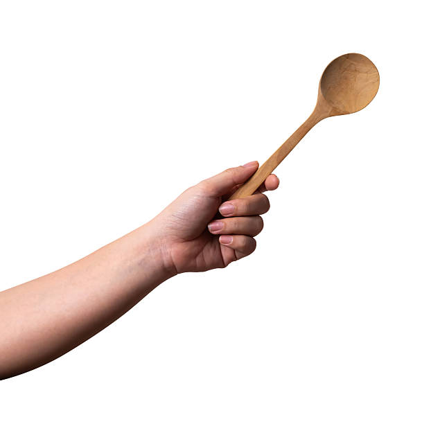 istock Female hand holding a wooden spoon isolated on white background. 2248164465