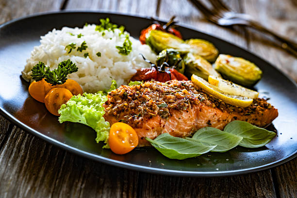 Baked salmon with white rice on wooden table
