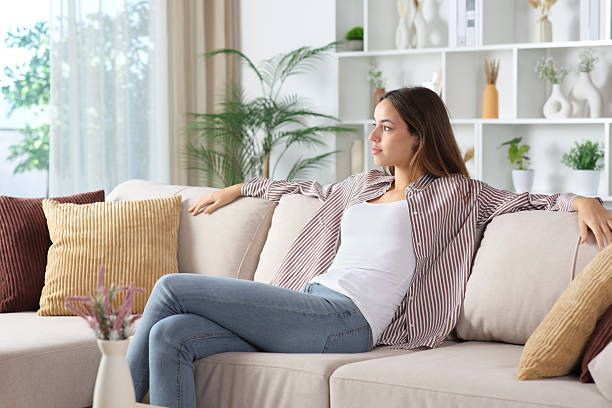 istock Relaxed woman looking away thinking alone at home 2248164729
