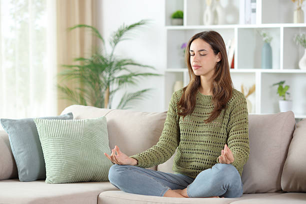istock Woman in green doing yoga exercises on a sofa 2248164834