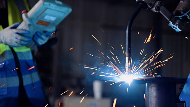 istock Future of Manufacturing: Welding Robot Working with Human Supervision 2248164943
