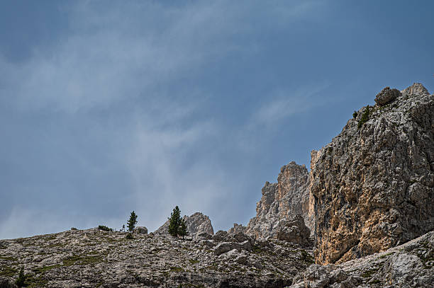 high rock canyon at sunrise with clear blue sky  in autumn with yellow trees in italian dolomites alps mountains