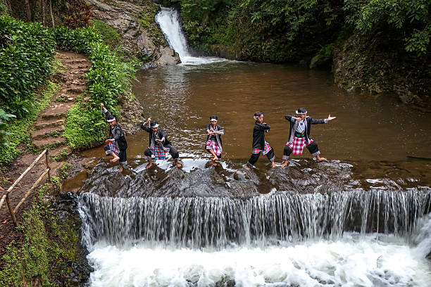 Aerial Shot of Indonesian Pencak Silat Artists Performing Traditional Stances Near a Waterfall