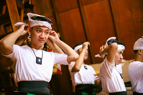 Balinese man smiling and pointing to blank mobile phone screen that he hold