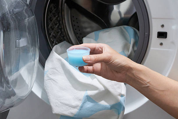 istock Woman's hand adding fabric softener to washing machine. 2248166715