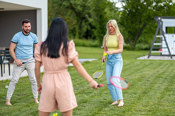 istock Cheerful Diverse Young Friends Playing Badminton Outdoors in a Lush Backyard on a Sunny Day 2248167072