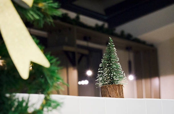 istock A miniature artificial Christmas tree with snow-covered branches stands on a wooden base as part of festive indoor décor. 2248167431