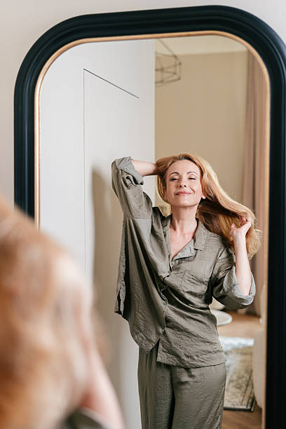 istock Woman enjoying her morning routine in pajamas while looking in the bathroom mirror 2248167925