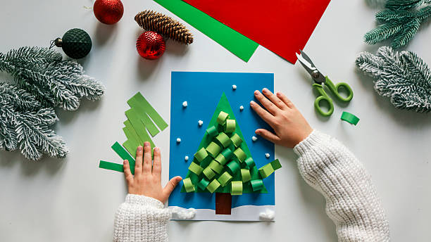 istock Child's hands crafting a Christmas tree with paper and decorations 2248168150