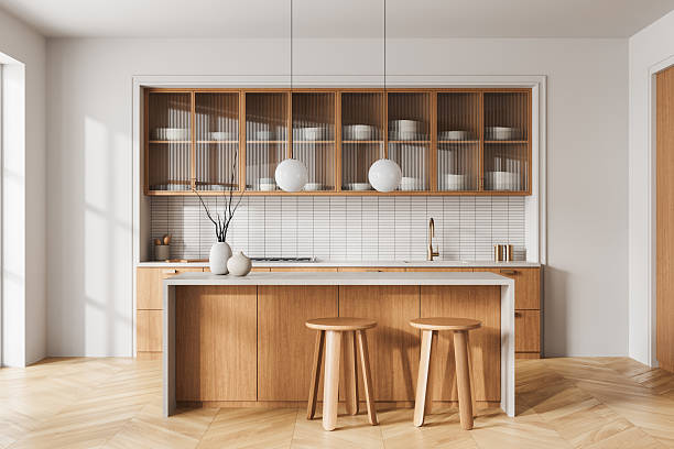 istock Modern minimalist kitchen interior with wooden cabinets, white countertop, and pendant lighting in bright natural light on parquet flooring. 3D Rendering 2248168911