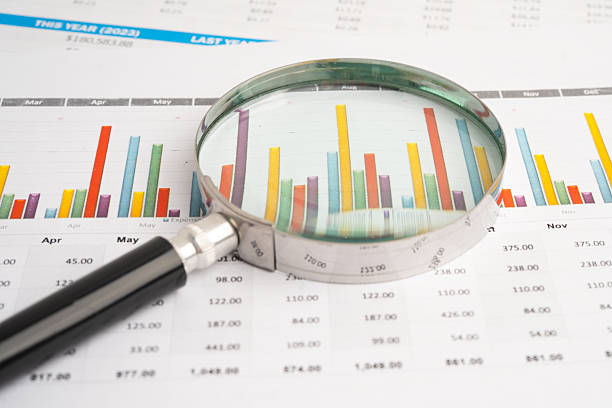 istock Magnifying glass on data business graphs paper. 2248170443