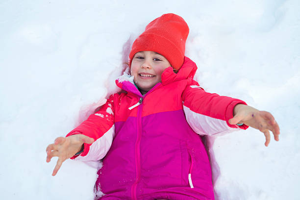 Smiling Happy Girl making a snow angel