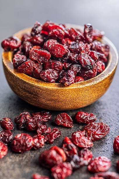 istock Tasty dried cranberries in bowl on black table. 2248171969