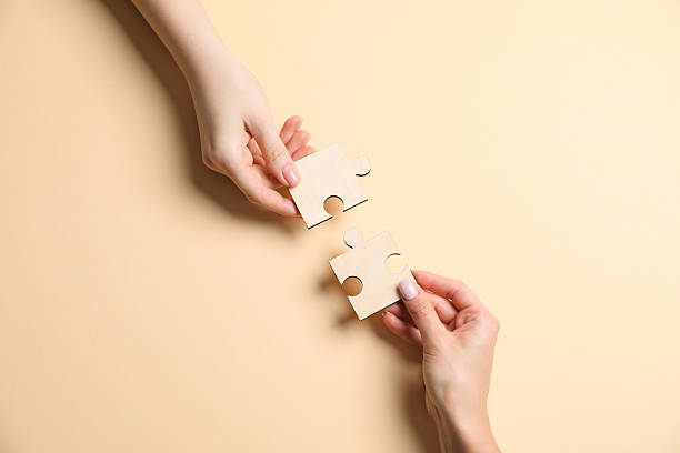 istock Business strategy and teamwork concept. Partners putting puzzle pieces together on beige background, top view 2248176414