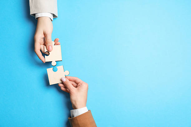 istock Business strategy and teamwork concept. Partners putting puzzle pieces together on light blue background, top view. Space for text 2248176472