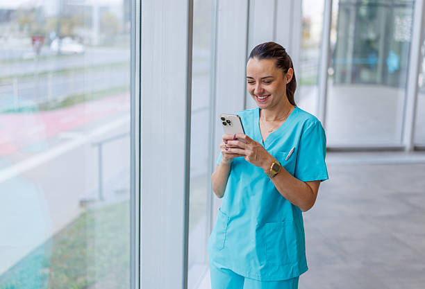 istock Nurse smiling and typing on mobile phone during break 2248177071