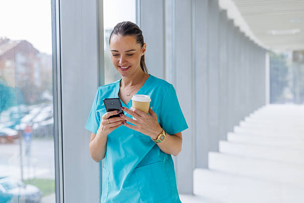 istock Healthcare worker on coffee break using smartphone in hospital corridor 2248177393