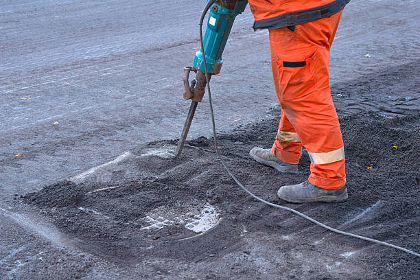 istock Repair.A road worker breaks up old asphalt with a jackhammer 2248179225