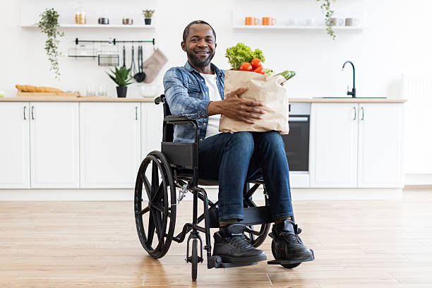 istock Man in Wheelchair with Groceries 2248180833
