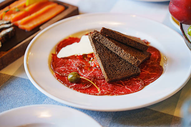 An artistic arrangement of cured meat slices in rows, showcasing their textures and color variations. ideal for culinary, cooking, and food-related themes.