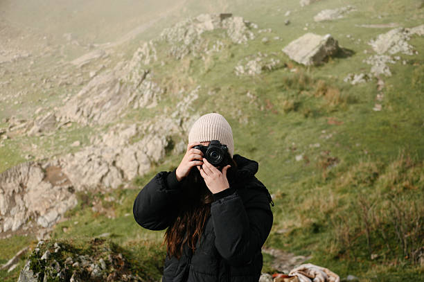 istock Young woman taking a picture with a camera 2248182569